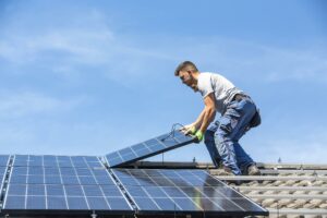Zeitenwende für die Solarenergie? - Handwerker installiert PV-Anlage auf einem Dach