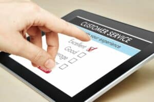 Customer Service - Hand bewegt sich auf Pad um Umfrage zu beantworten zu Kundenzufriedenheit