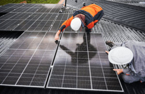 Zwei PV-Installateure montieren Solarmodule auf ein Dach