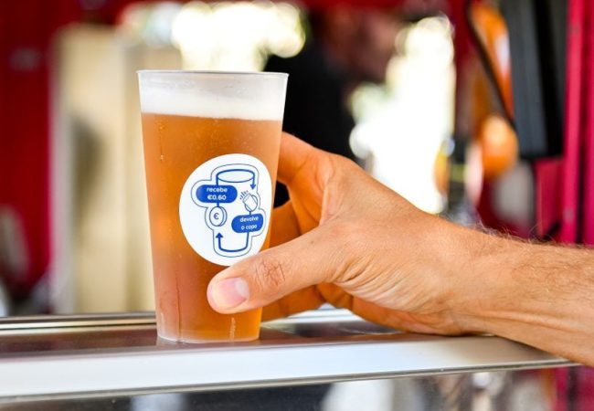 Hand hält Bierglas mit QR-Code im Pub.